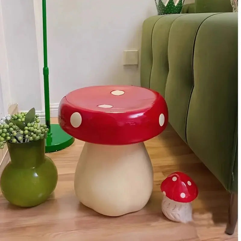 Red and white mushroom-shaped stool in a room with a green couch and plant.