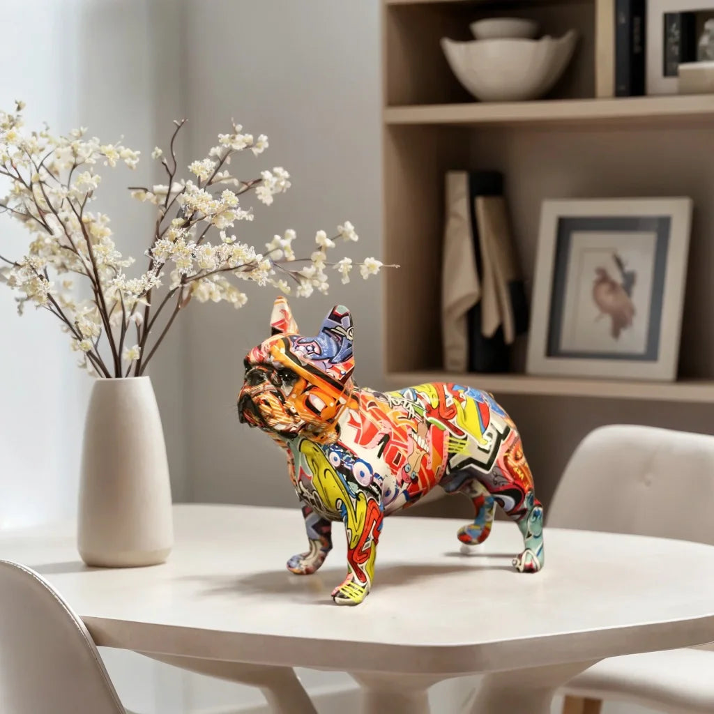Colorful bulldog sculpture on a table with a vase of flowers and books in the background frenchie, french bulldog
