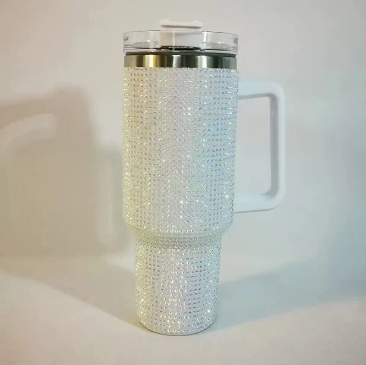 Blush pink tumbler with rhinestone embellishments on a white background