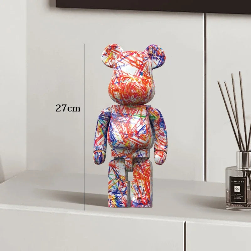 Colorful bear-shaped figure on a white surface with a vase in the background be@rbrick collectable
