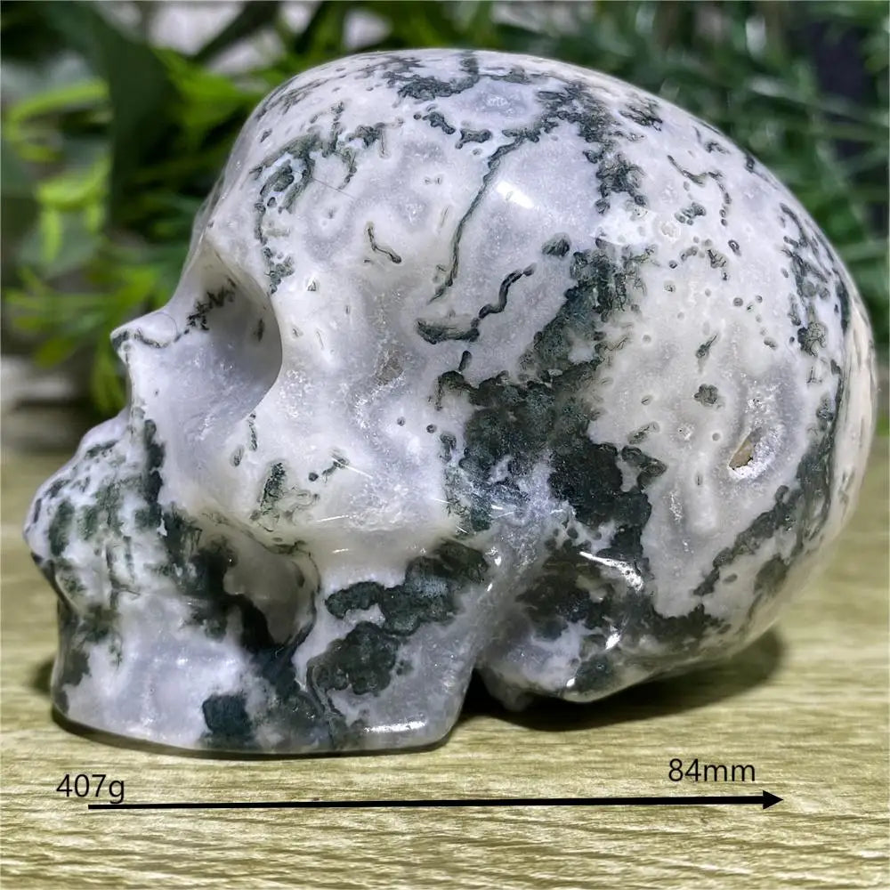 Carved stone skull with measurement details on a wooden surface