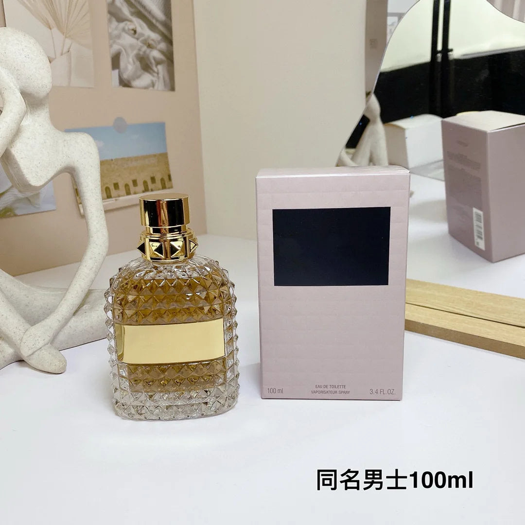 Valentino Perfume bottle with gold cap and label next to its packaging on a white surface.