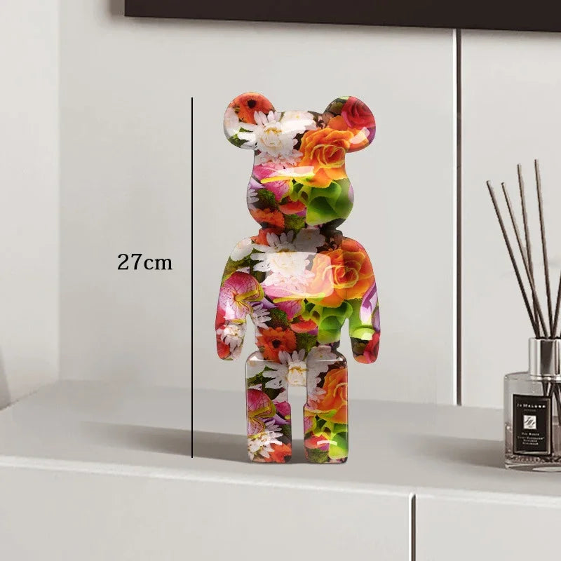 Colorful floral-patterned bear figure on a white surface with a measurement label, next to a diffuser. be@rbrick collectable