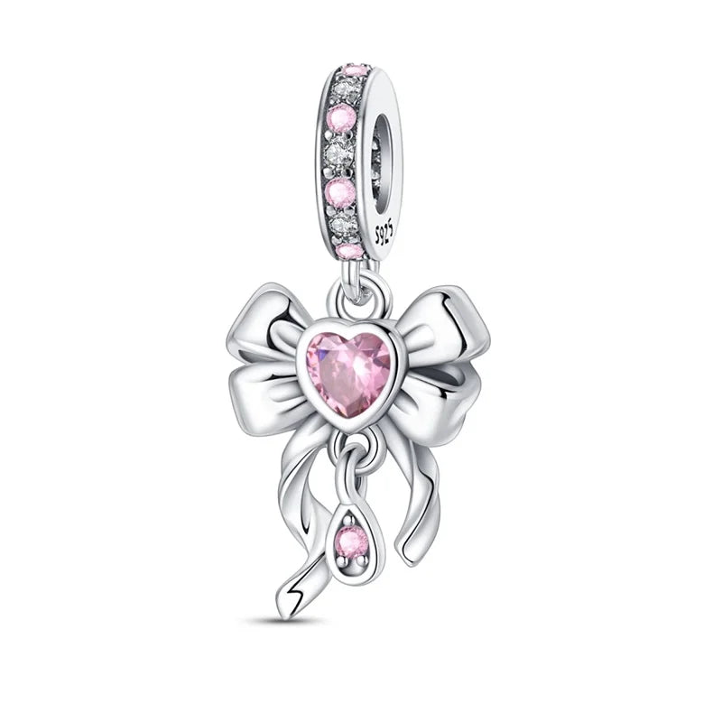 Silver charm with pink heart and bow design on a white background
