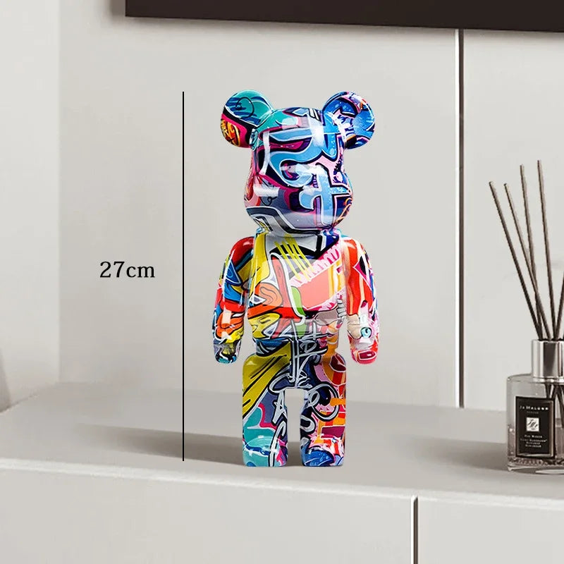 Colorful bear-shaped figure on a white surface with a measurement label, next to a diffuser. be@rbrick collectable