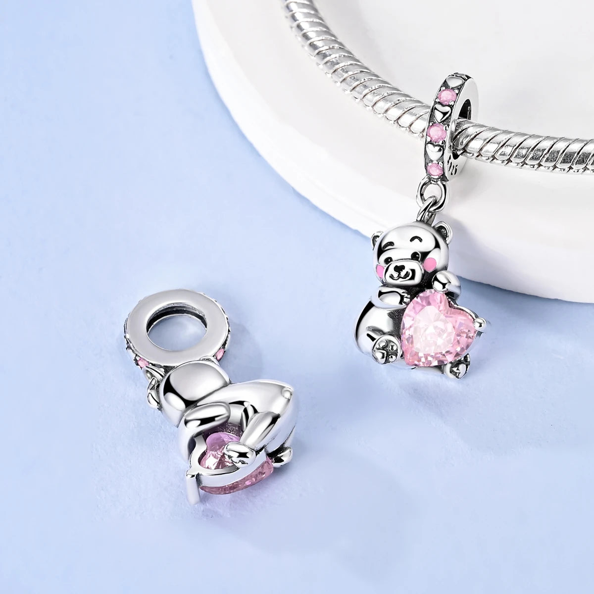 Silver and pink charm with a heart design on a light blue background. pandora style