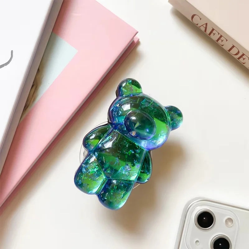 Colorful bear-shaped air freshener on a white surface with books in the background