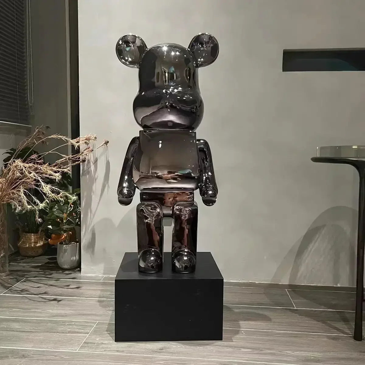 Shiny black bear-like sculpture on a pedestal in an indoor setting bearbrick collectable