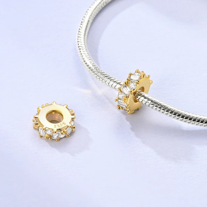 Gold and silver beaded charm on a white background