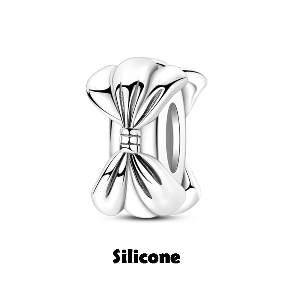 Silver bow-shaped charm on a white background with 'Silicone' text below.