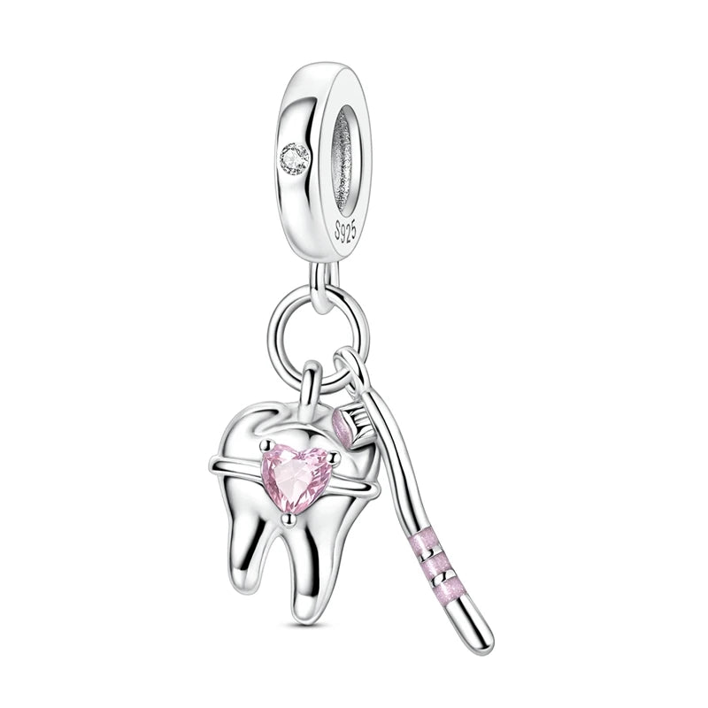 Silver dental themed charm with pink gemstones on a white background