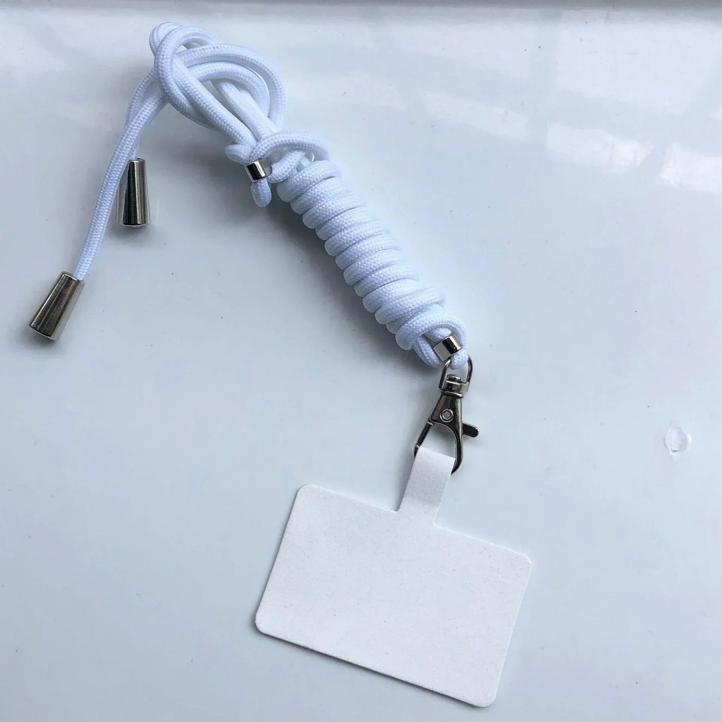 White lanyard with a clip and blank badge on a light gray background