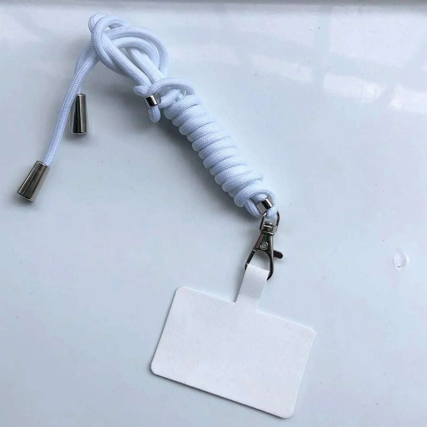 White lanyard with a clip and blank badge on a light gray background
