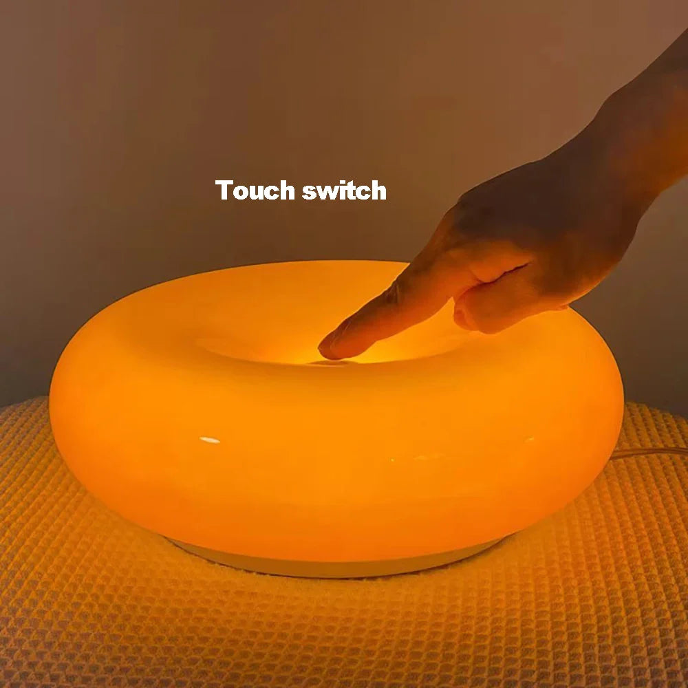 Hand pressing a touch switch on an orange glowing object.
