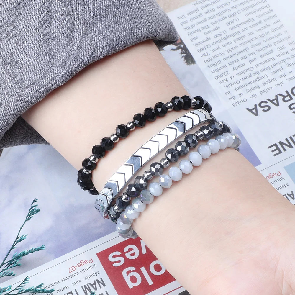 Three beaded bracelets on a wrist with a newspaper background