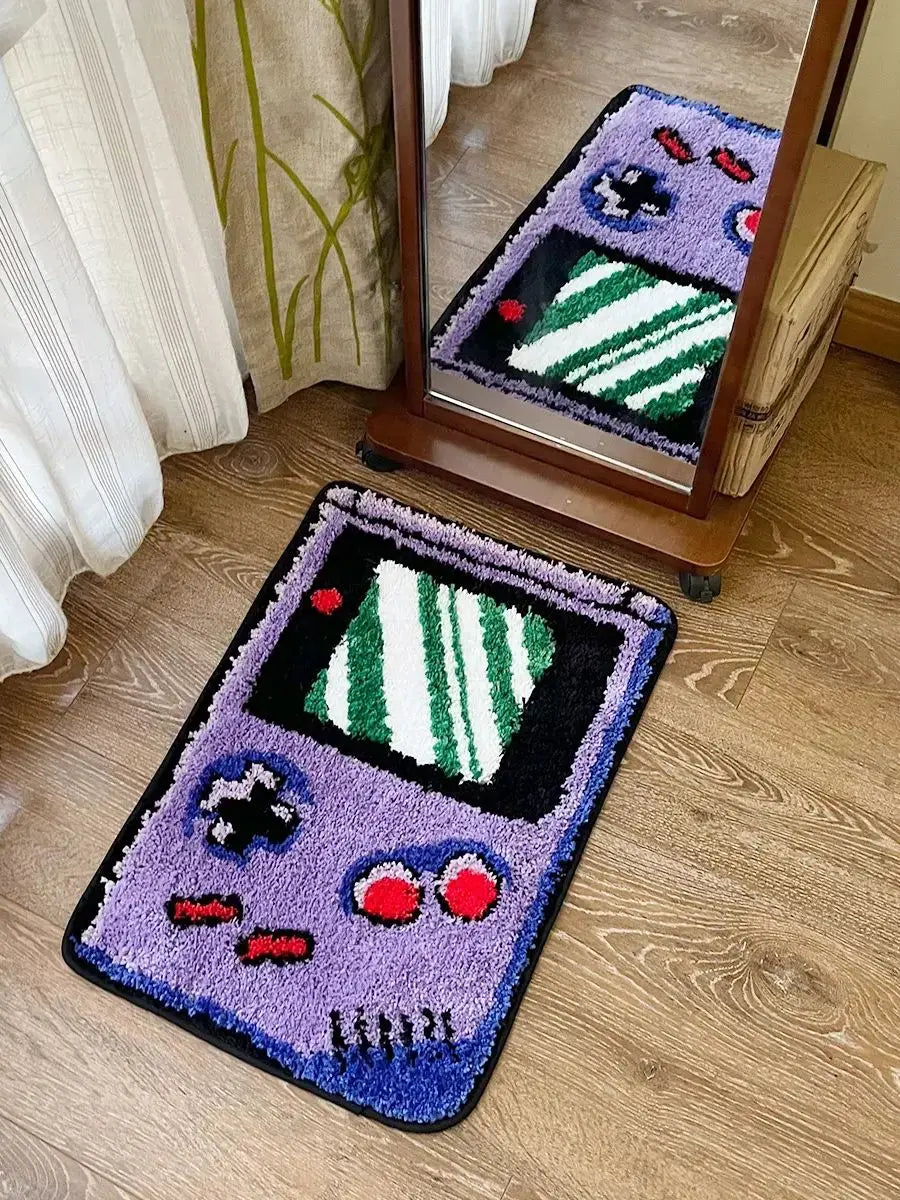 Game console-shaped rug on a wooden floor with a mirror reflecting part of the room.