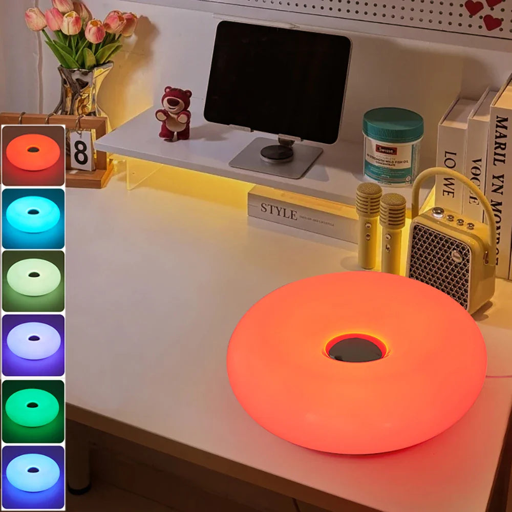 Color-changing LED strip on a desk with a monitor and decor items.