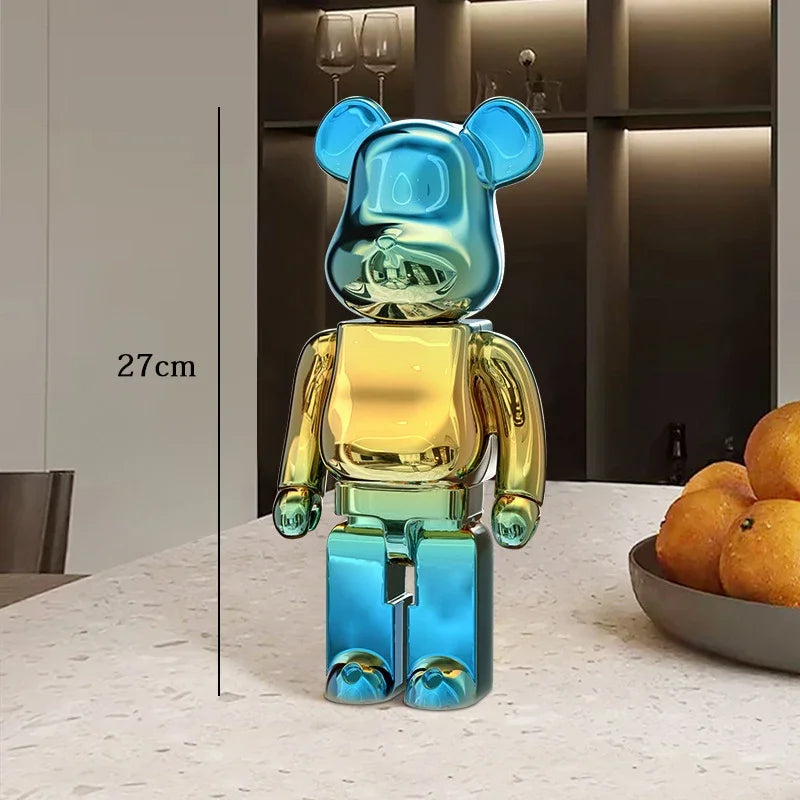 Multicolored bear-shaped figure on a table with a bowl of oranges in the background be@rbrick collectable