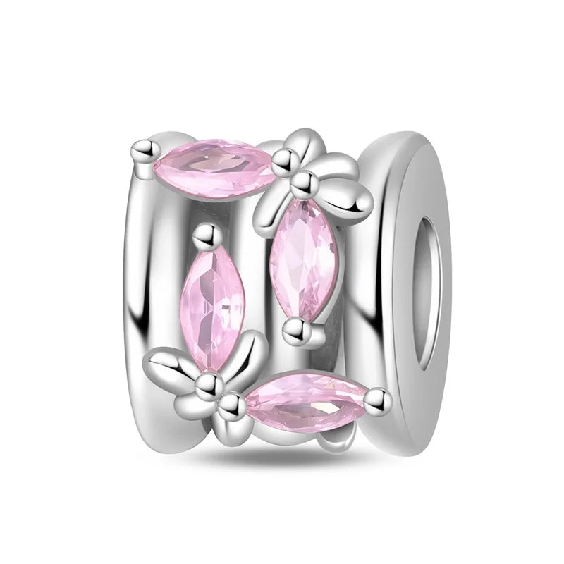 Silver charm with pink gemstones on a white background