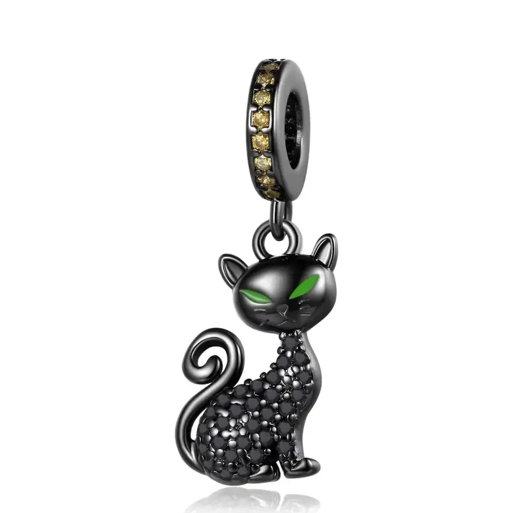 Black cat charm with green eyes on a white background