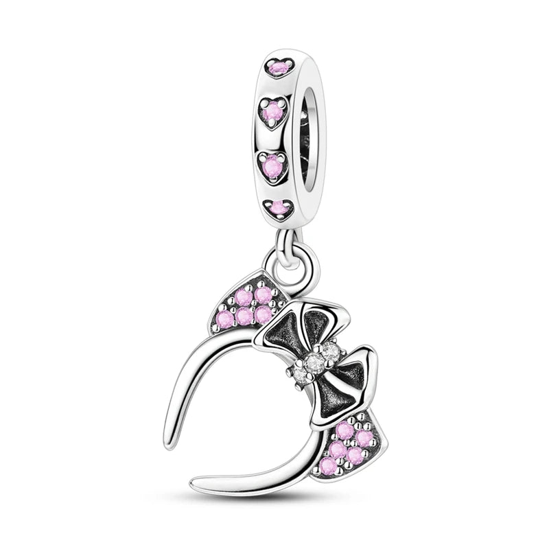 Silver charm with pink headband s
haped stones on a white background