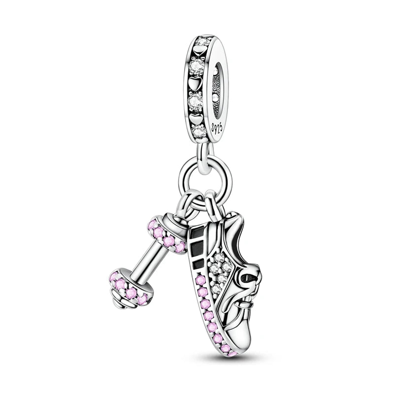 Silver charm with pink crystals shaped like a shoe and a boot on a white background