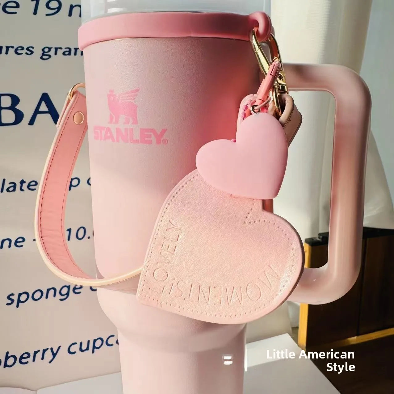 Pink Stanley mug with heart-shaped keychain on a blurred background