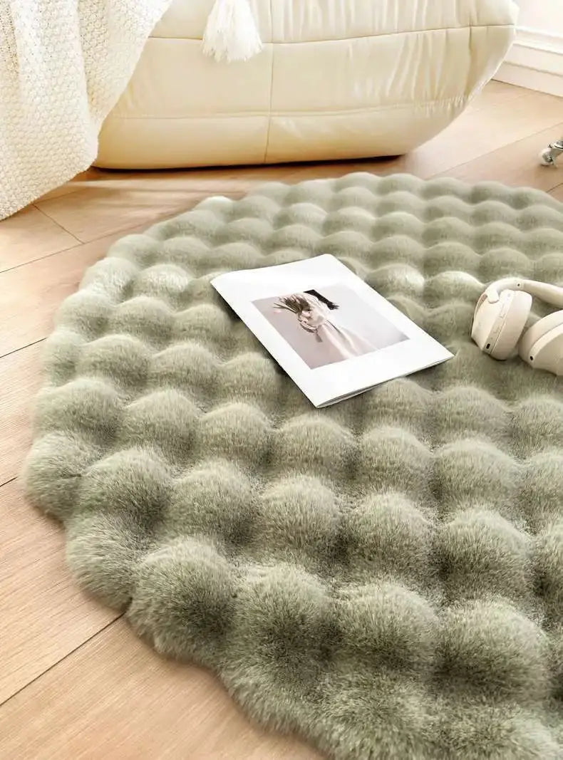 Round green rug on a wooden floor with a photo and small plant on top