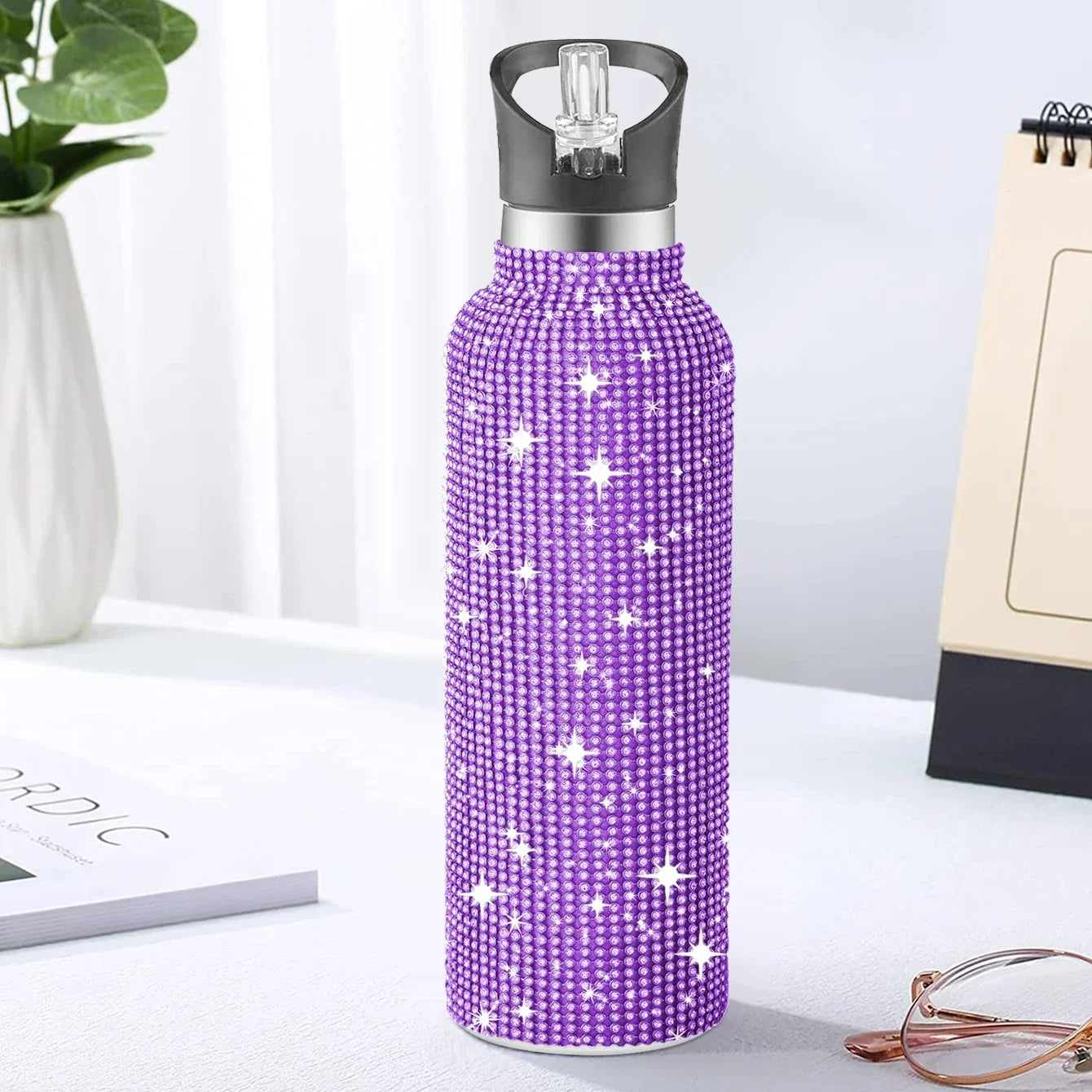 Purple water bottle with star pattern on a white surface