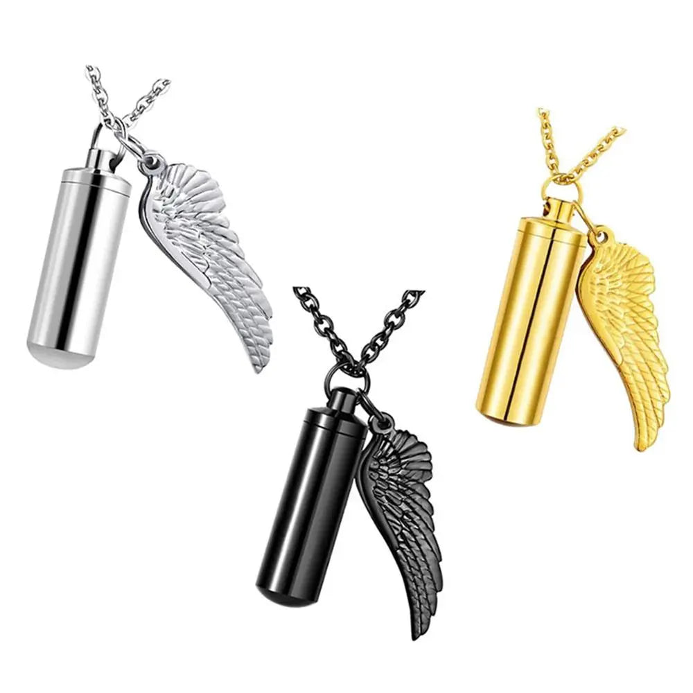 Three cylinder-shaped cremation urn necklaces in silver, gold, and black colors, each with angel wings and a chain.