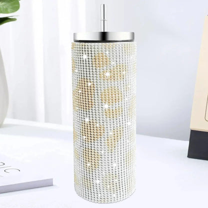 Decorative cylindrical object with rhinestone embellishments on a white surface.