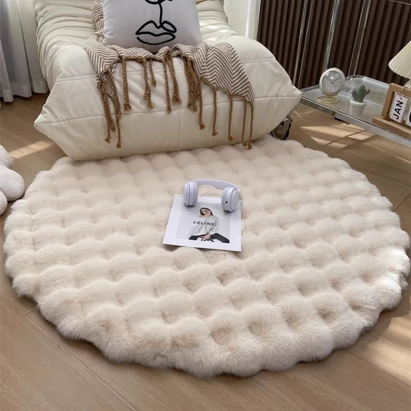 Round white fluffy rug on a wooden floor with a chair and decorative items in the background.