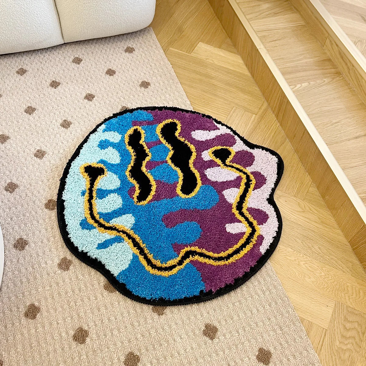 Colorful abstract rug with black, blue, and purple design on a beige carpet.