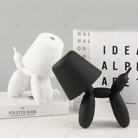 Black and white dog-shaped objects on a light gray surface with books in the background.