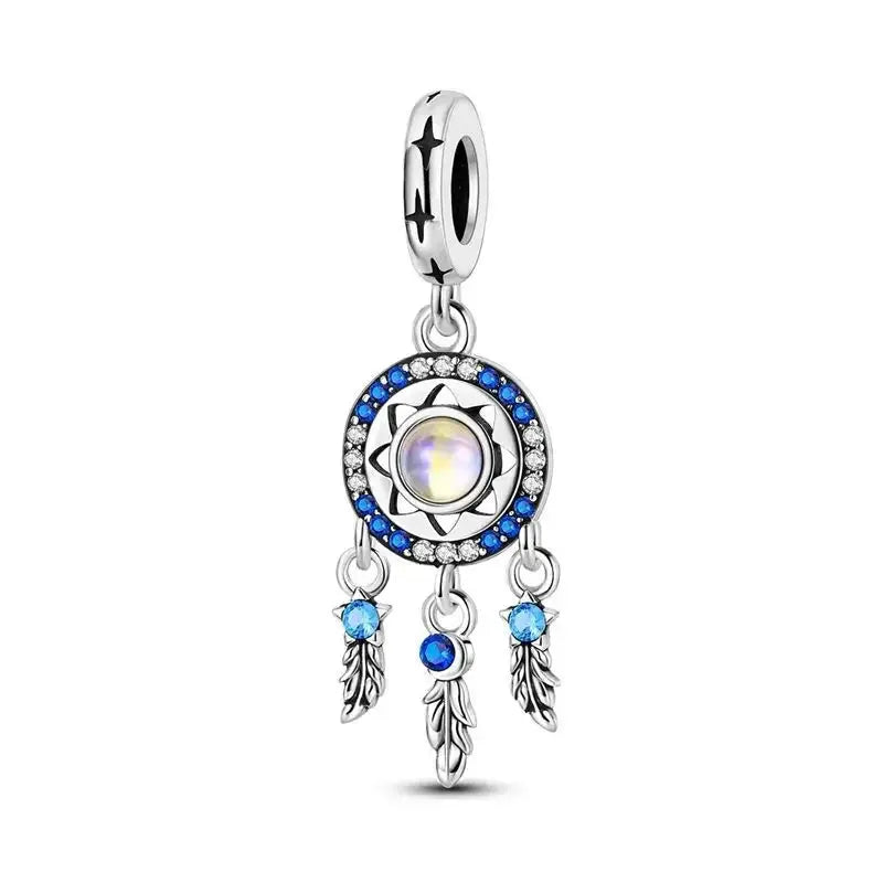Silver charm dream catcher with a central gemstone and blue accents on a white background