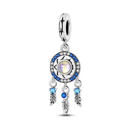 Silver charm dream catcher with a central gemstone and blue accents on a white background