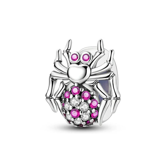 Silver spider charm with pink and clear gemstones on a white background