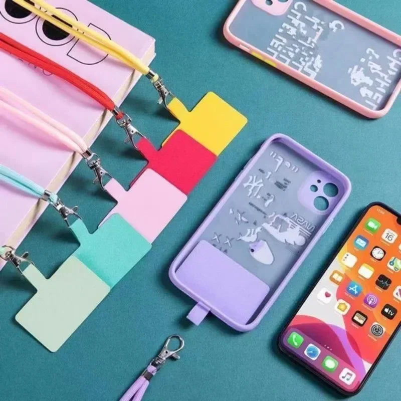 Colorful phone cases with lanyards on a teal background