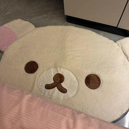 Cushion shaped like a bear face with brown eyes and nose on a light background