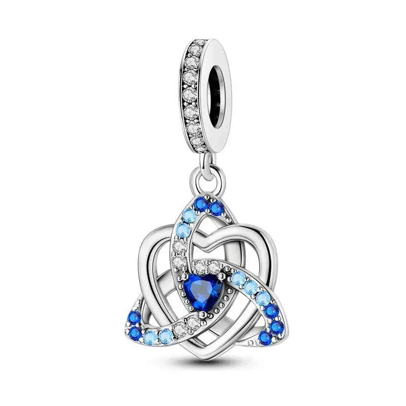 Silver pendant with blue heart and clear stones on a white background