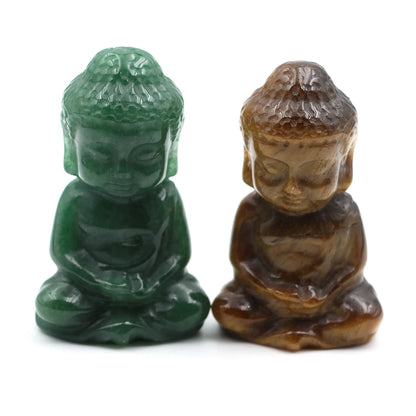 Two small Buddha statues, one green and one brown, on a white background