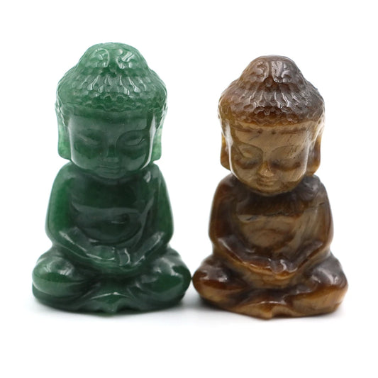 Two small Buddha statues, one green and one brown, on a white background