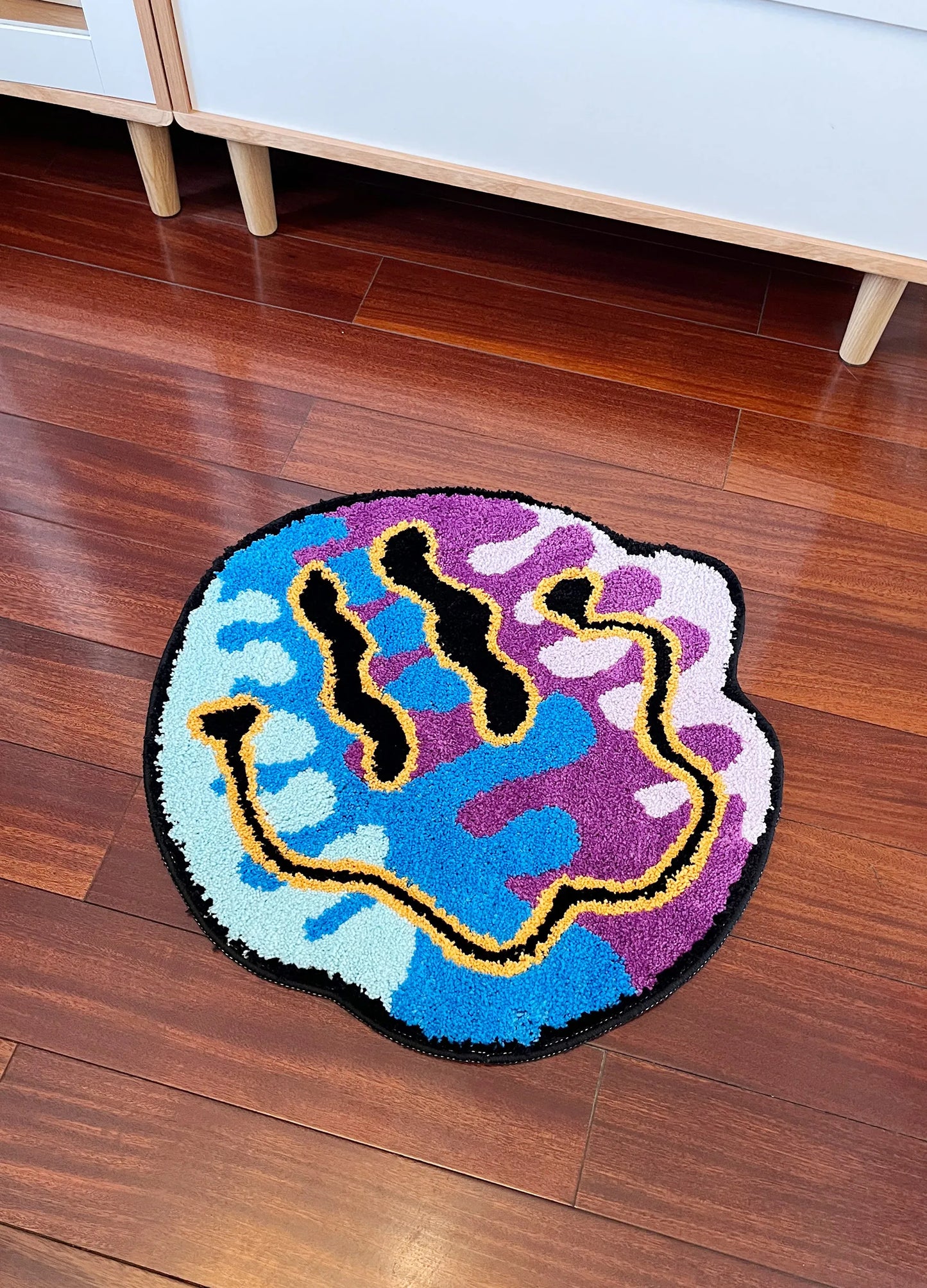 Colorful hand-shaped rug on a wooden floor