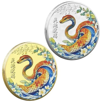 A collectible coin with a 3D relief design of a snake and floral patterns, predominantly in gold and silver colors.