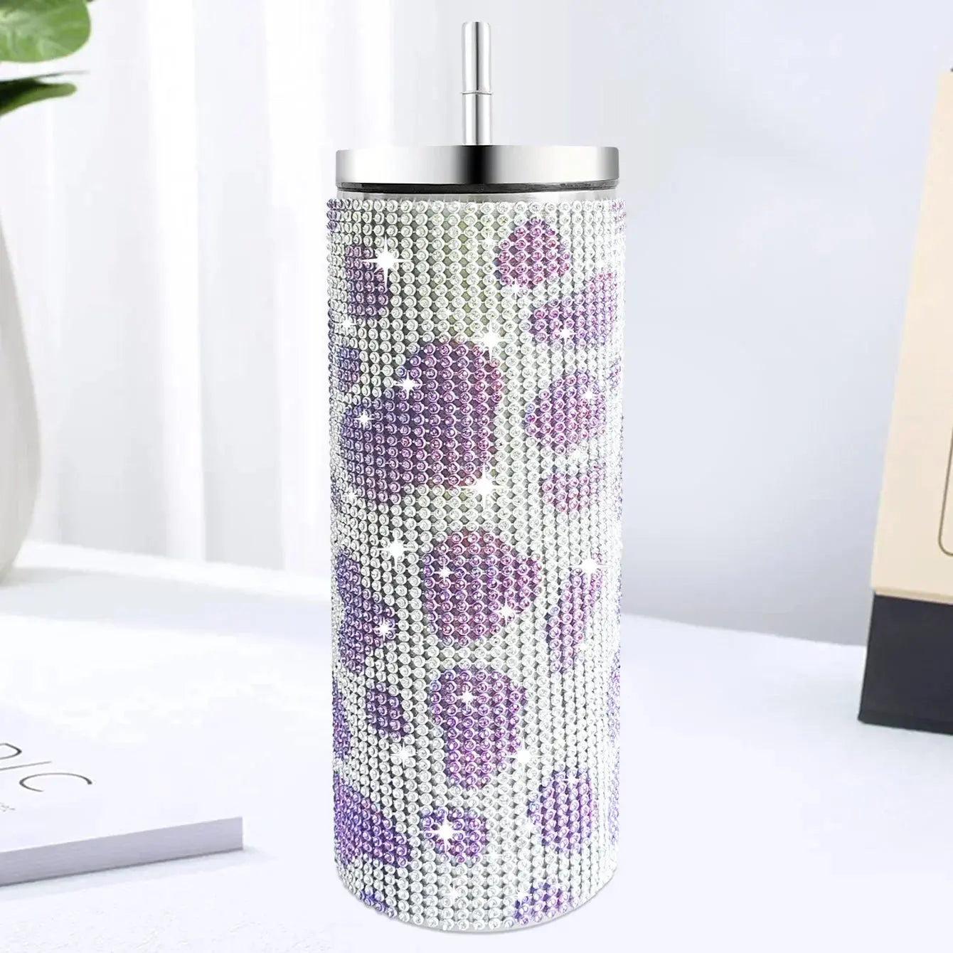 Tumbler with purple floral pattern on a white surface