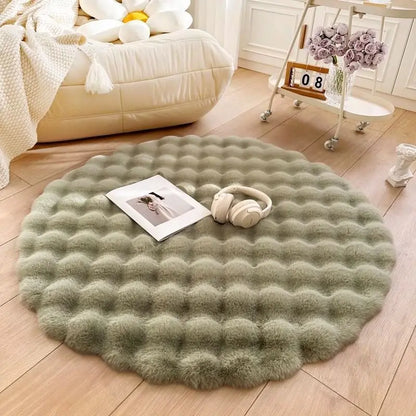 Round green rug on a wooden floor with a book and headphones on top, in a cozy living room setting.