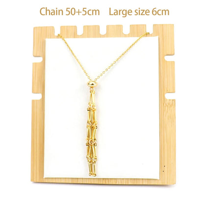 Gold necklace with tassel on a wooden display stand