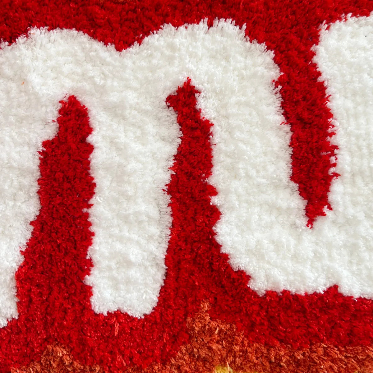 Close-up of a textured red and white surface with letter 'D'.