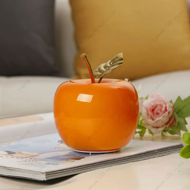 Orange apple-shaped object on a magazine with a blurred background
