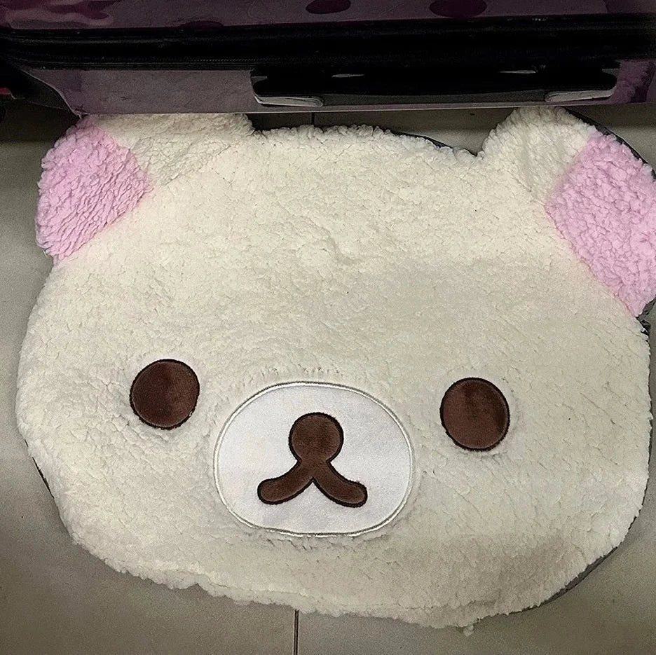 Plush toy with pink ears and a white face on a gray surface